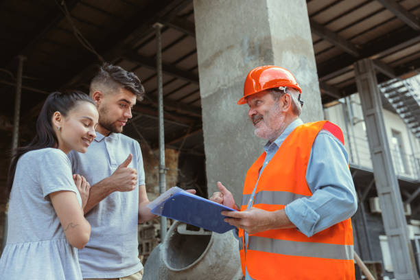 istock Foreman or achitect shows house, office or store design plans to a young couple 1167767286