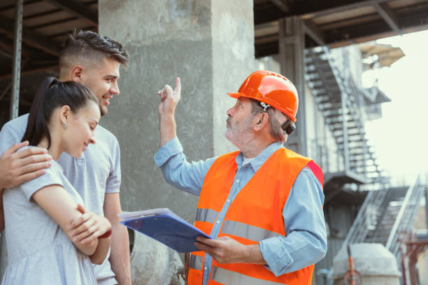 istock Foreman or achitect shows house, office or store design plans to a young couple 1167767290
