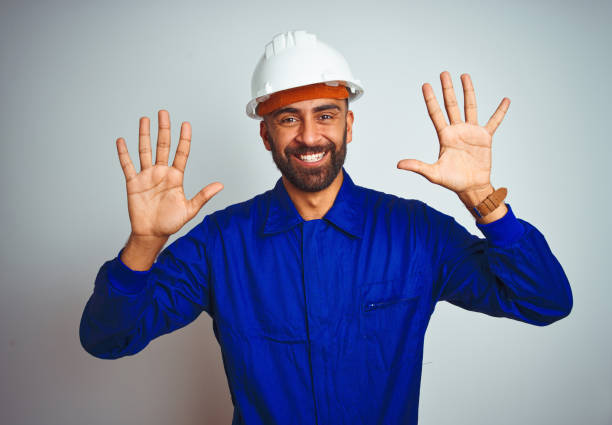 istock Handsome indian worker man wearing uniform and helmet over isolated white background showing and pointing up with fingers number ten while smiling confident and happy. 1167770747