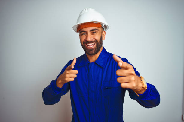 istock Handsome indian worker man wearing uniform and helmet over isolated white background pointing fingers to camera with happy and funny face. Good energy and vibes. 1167770793