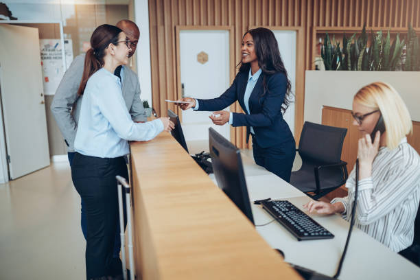 istock Friendly concierge helping two guests check in to a hotel 1167772437