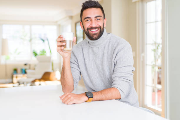 istock Handsome hispanic man drinking a cup of coffee with a happy face standing and smiling with a confident smile showing teeth 1167772881