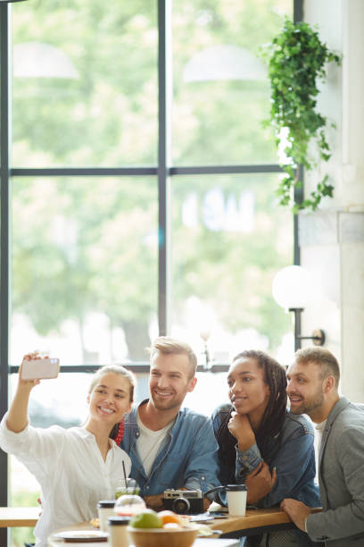 istock Happy optimistic young multi-ethnic friends making group selfie in modern cozy cafe 1167774629