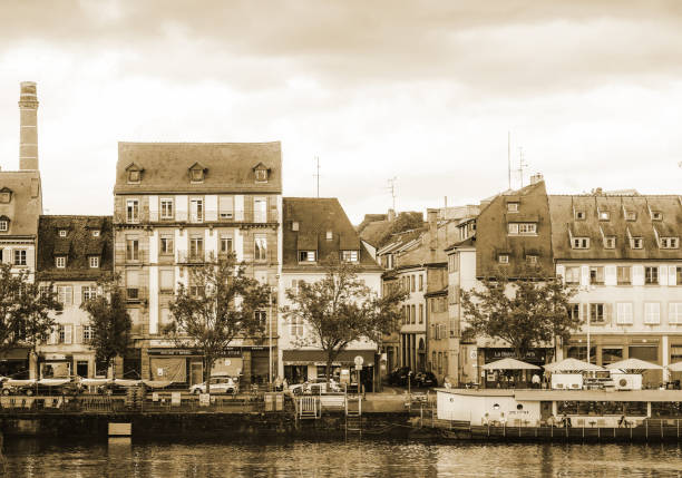 Strasbourg, France - Jul 12, 2017: Iconic Quai des Pecheurs street with traditional timbered houses, restaurant peniches and terraces on the calm street in central Strasbourg black and white
