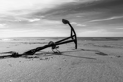 Rusty boat anchor on the beach