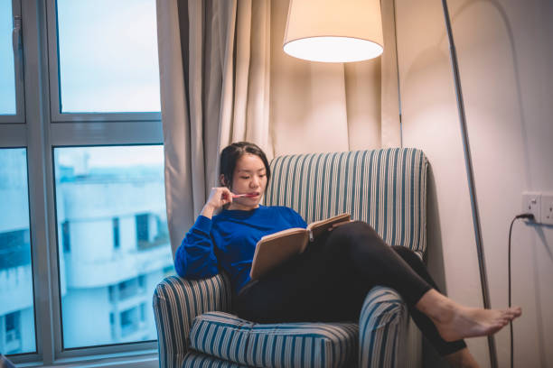 istock a young asian chinese female student sitting on sofa studying holding pen and note book preparing her exam 1167776083