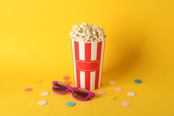 istock Striped bucket with popcorn and 3d glasses on yellow background, copy space 1167776279