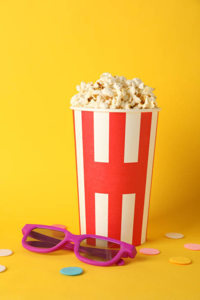 istock Striped bucket with popcorn and 3d glasses on yellow background, copy space 1167777094