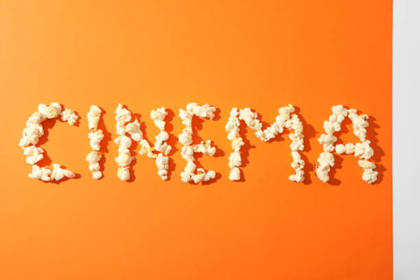 istock Word cinema laid out from popcorn on orange background, copy space 1167777147