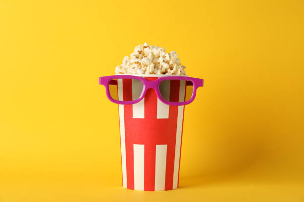 istock Striped bucket with popcorn and 3d glasses on yellow background, copy space 1167777157