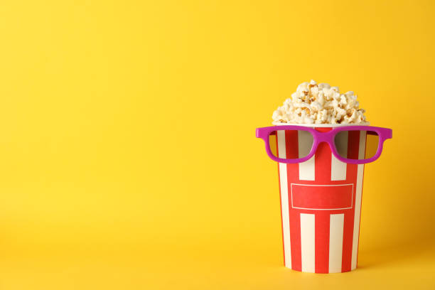 istock Striped bucket with popcorn and 3d glasses on yellow background, copy space 1167777163