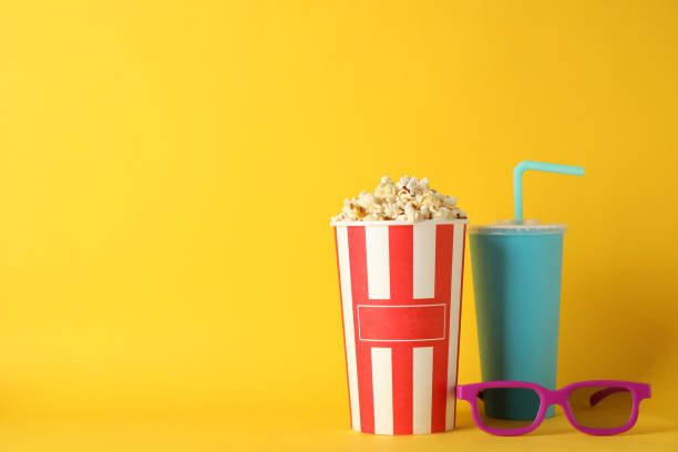istock Bucket with popcorn, drink and 3d glasses on yellow background, space for text 1167777184