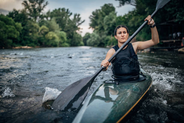 Whitewater kayaking, extreme kayaking. Woman in a kayak sails on a mountain river