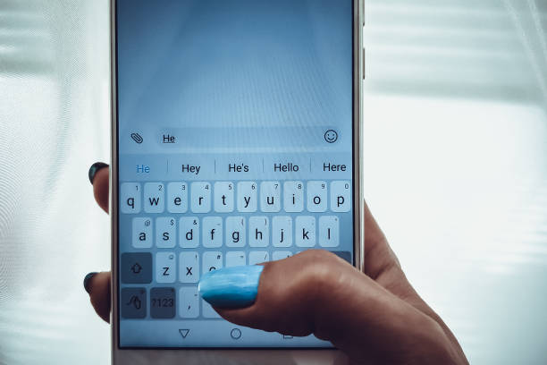 istock Female hand with blue nails is typing on a white phone a message 1167778924