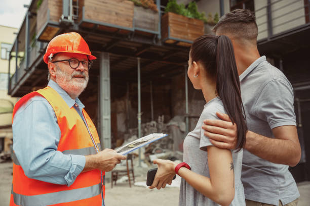 istock Foreman or achitect shows house, office or store design plans to a young couple 1167781121