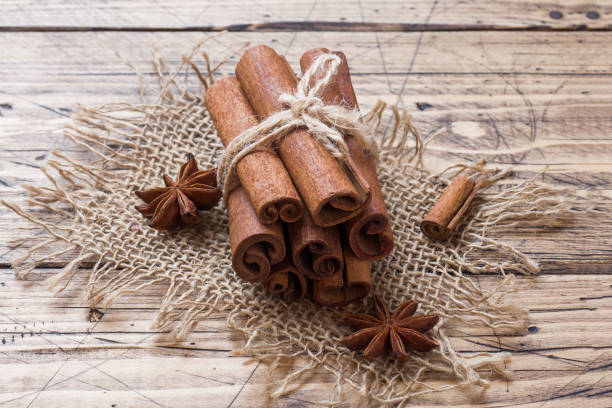 unos cuantos palitos de canela atados con hilos y estrellas de anís sobre un fondo de madera. copiar espacio. enfoque selectivo. - badian fotografías e imágenes de stock