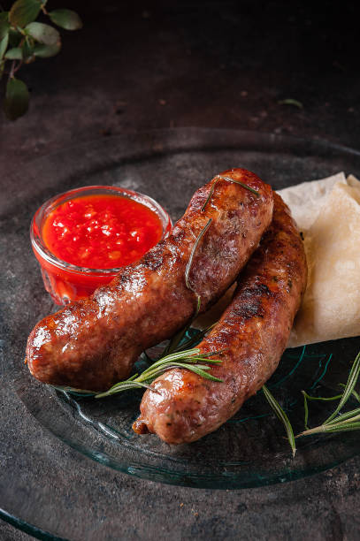 istock Fried domestic sausages with sauce on dark background,selective focus 1167782307