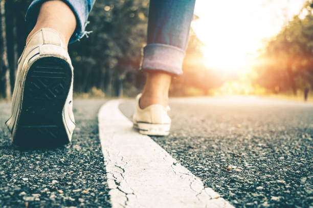 istock Low Section Of Woman Walking On Road 1167786681