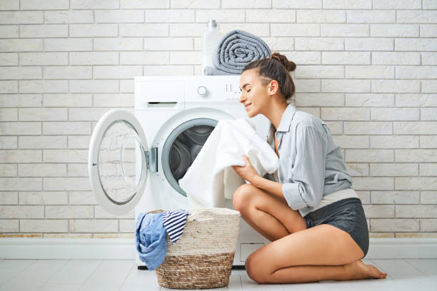 mujer está haciendo la colada - attractive female indoors lifestyles clean fotografías e imágenes de stock