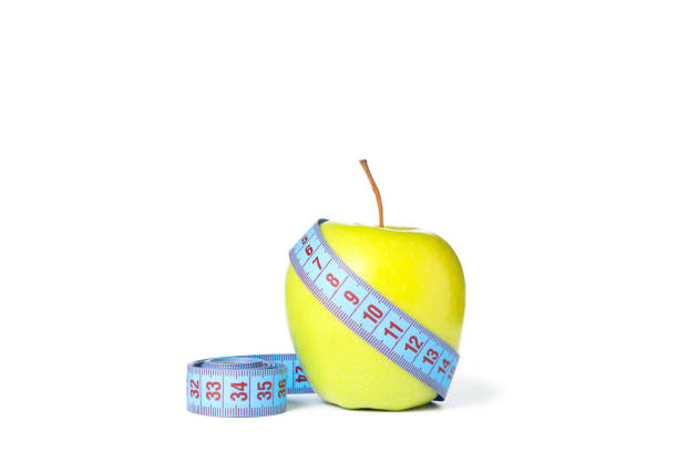 istock Measuring tape and apple isolated on white background 1167791881