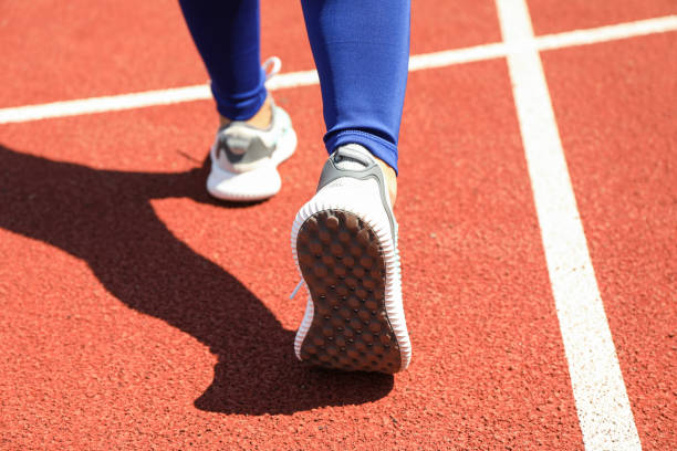 istock Girl walking on red athletic track, close up 1167792664