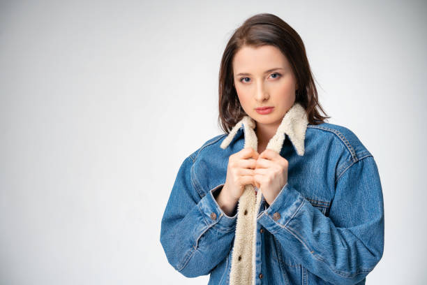 istock beautiful young woman in denim jacket posing on white background 1167792784