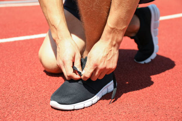 istock Man tying shoelaces on red athletic running track, close up 1167793226