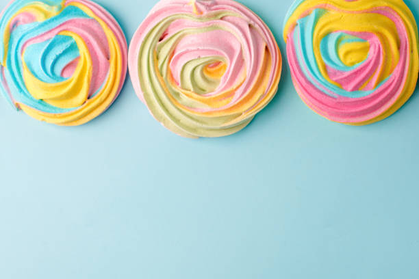 istock meringues in unicorn rainbow pastel colors, frame and copy space on blue backgound, simple minimal 1167794863