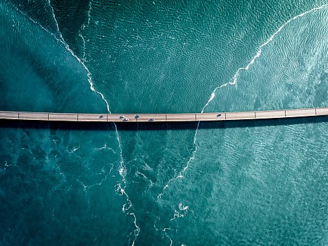 Aaerial photograph of the beautiful sea and bridge in Iceland. Cars are crossing the bridge to reach their destination.