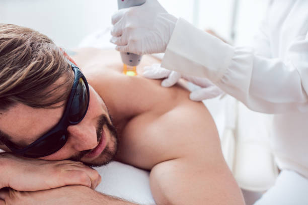 Man in a hair removal studio Man under treatment in a hair removal studio hair removal photos stock pictures, royalty-free photos & images