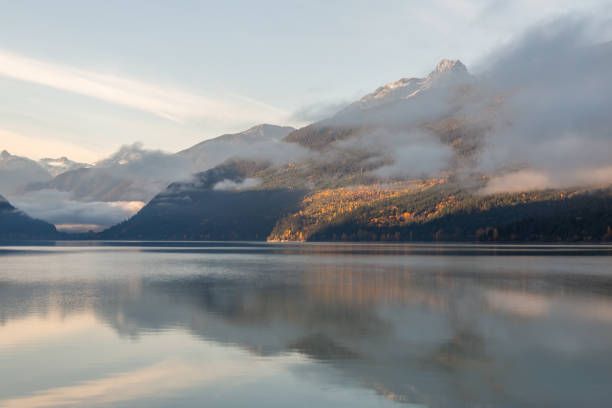 Sunrise over a misty mountain lake in the fall.