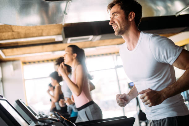 istock Beautiful fit people exercising together in gym 1167800456