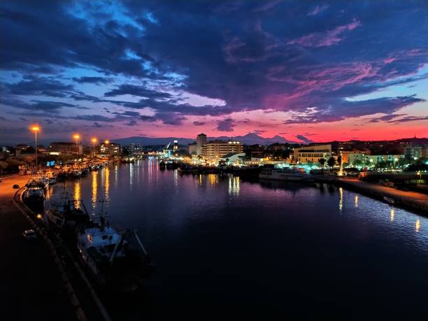 istock Illuminated City By River Against Sky At Sunset 1167803463