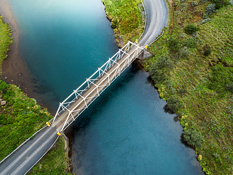 Aerial photo of an old bridge over a river with calm water in the beautiful and colourful landscape of Iceland