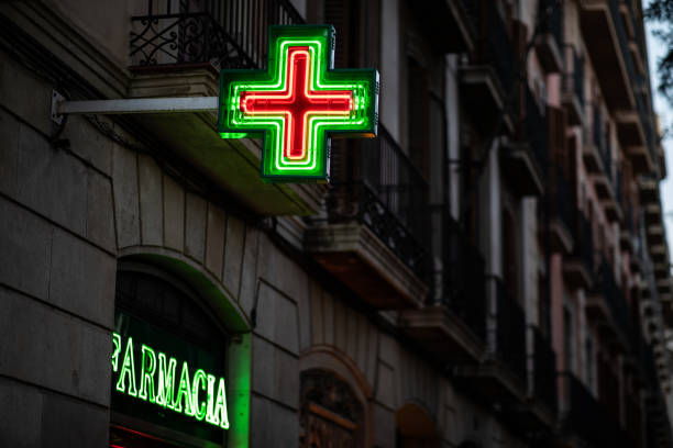 Pharmacy signs illuminated at night on spanish architecture facade with copy space Pharmacy signs illuminated at night on spanish architecture facade with copy space pomegranate in spanish stock pictures, royalty-free photos & images