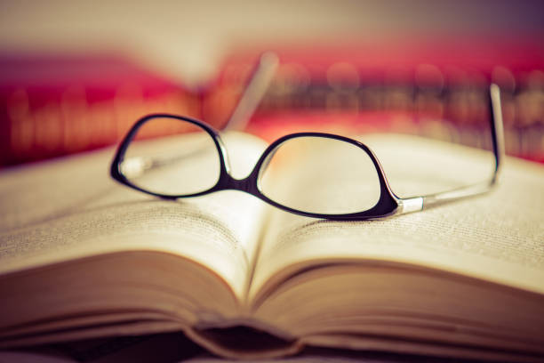 istock Glasses lies on red books 1167807663