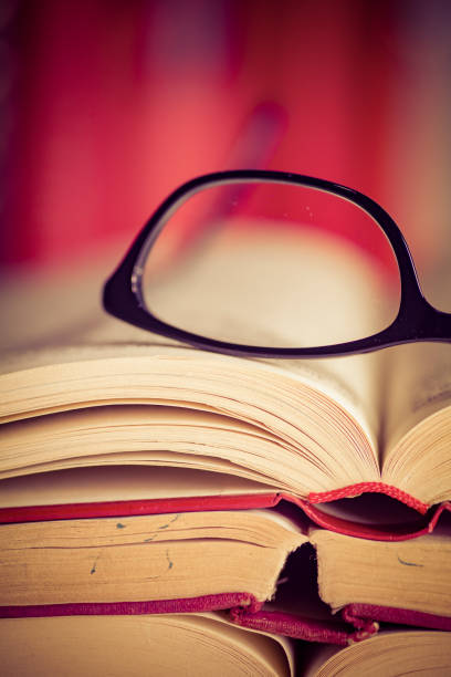 istock Glasses lies on red books 1167807739