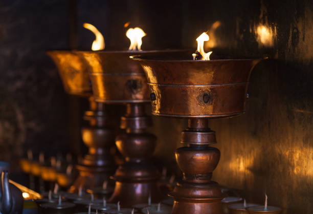 Big oil lamps burn in the Buddhist temple, as fire gift from pilgrims.