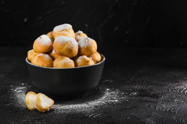 istock Eclairs with cottage cheese in a black bowl on a dark background closeup with copyspace 1167808908