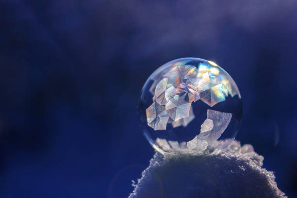 istock Frozen soap bubble ball on snow in sunset, crystal formation, winter background with copy space 1167812942
