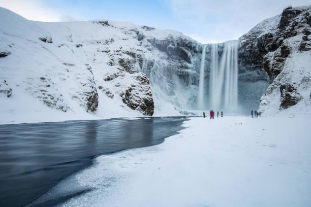 Skogafoss Panorama in Winter Famous skogafoss Waterfall in iceland on a winter day with some tourists arround.Famous skogafoss Waterfall in iceland on a winter day with some tourists arround. skogafoss stock pictures, royalty-free photos & images