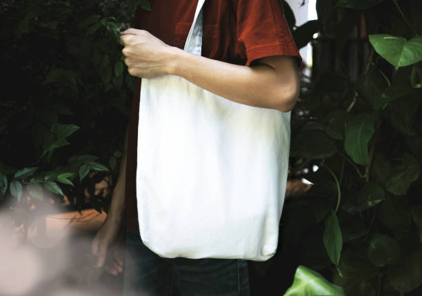istock Man is holding bag canvas fabric for mockup blank template on nature background.  global warming concept. 1167816418