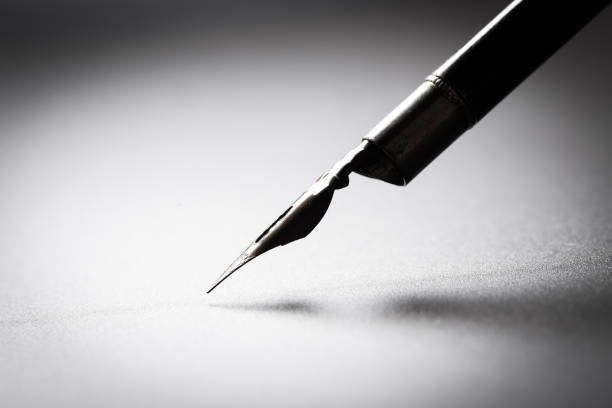 istock Old fountain pen on a black textured background 1167817442