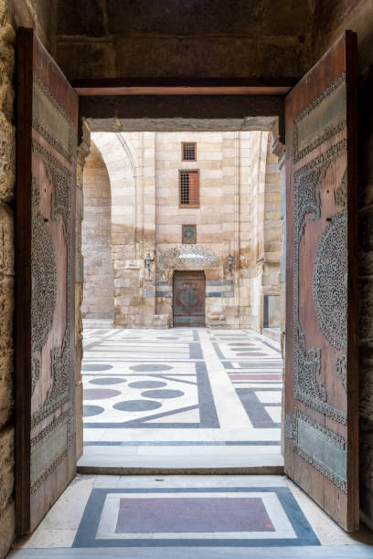 porta aperta che conduce al cortile della moschea di al-sultan al-ahir barquq, vecchio cairo, egitto - courtyard arch arabic style cairo foto e immagini stock