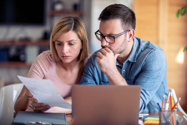 istock Photo of young couple using laptop and analyzing their finances 1167824803
