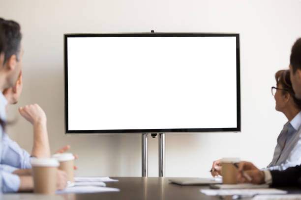 empresarios sentados en la sala de juntas mirando la televisión con blanco en blanco - lecture notes fotografías e imágenes de stock