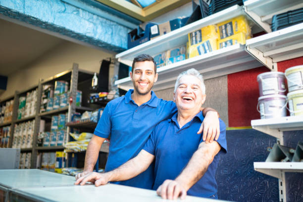 father and son working together in a paint store - small business built structure retail imagens e fotografias de stock