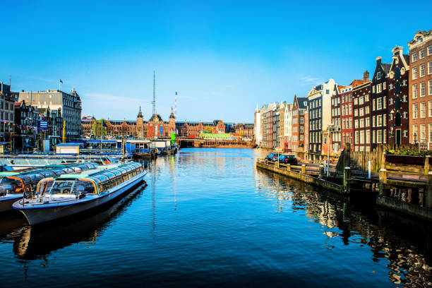 canal d'amsterdam avec des bateaux garés - magere brug photos et images de collection