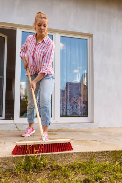 istock Woman cleaning patio using brush broom 1167830334