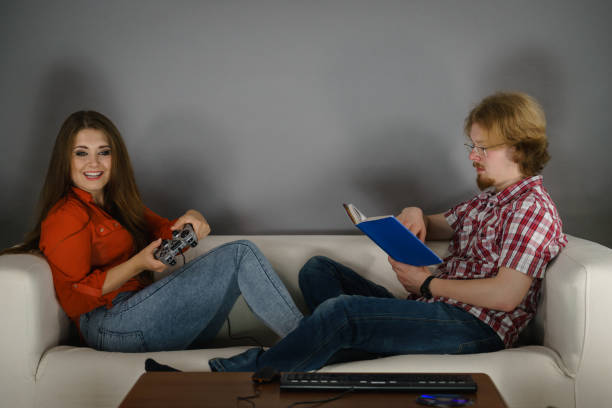 istock Woman playing games man reading book 1167832853
